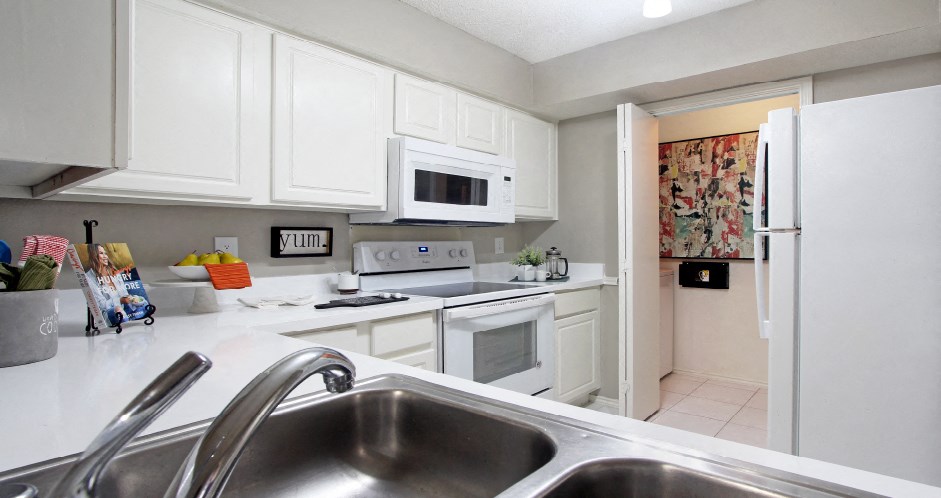 Bright white kitchen, spacious kitchen and full size and washer and dryer at Preston Village Apartments in North Dallas