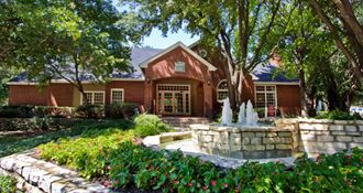 Luxury apartments in north Dallas with beautiful landscaping, scenic views, and red brick exteriors at PrestonVillage Apartments