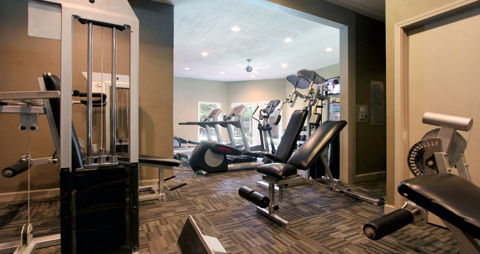 Luxury apartments with a fitness center in a gated community at Preston Village Apartments in North Dallas