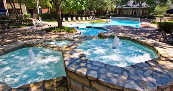 Luxury apartments with beautiful fountains, beautiful landscaping, swimming pool with poolside lounge chairs, and scenic views at Preston Village Apartments in north Dallas - Photo Gallery 4