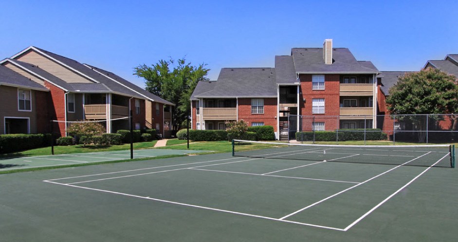 Luxury apartments with tennis court, red brick exteriors, beautiful landscaping, and spacious balconies at Preston Village Apartments in North Dallas