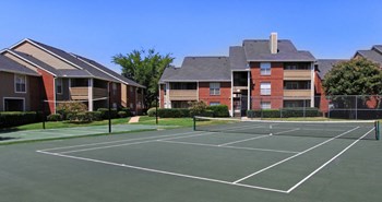 Luxury apartments with tennis court, red brick exteriors, beautiful landscaping, and spacious balconies at Preston Village Apartments in North Dallas - Photo Gallery 16