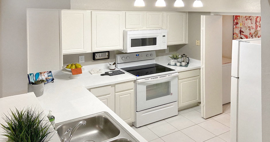 Bright white kitchen, spacious kitchen and full size and washer and dryer at Preston Village Apartments in North Dallas