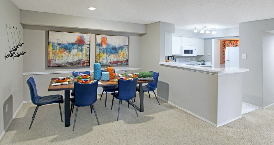 Spacious apartments with dining room and kitchen with white cabinets at Preston Village Apartments in north Dallas