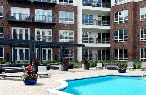 Luxury resort-style swimming pool with poolside cabanas and lounge chairs at Xenia Apartments in Golden Valley Minnesota