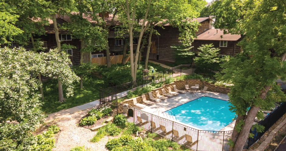 a backyard with a swimming pool and a house with trees