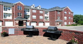Luxury apartments with red brick exteriors, resident grilling station, and attached garages at Rockledge Oaks Apartments in Lincoln, Nebraska - Photo Gallery 10