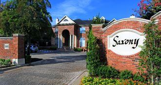 Gated luxury apartment community in north Dallas with red brick exteriors at The Saxony Apartments