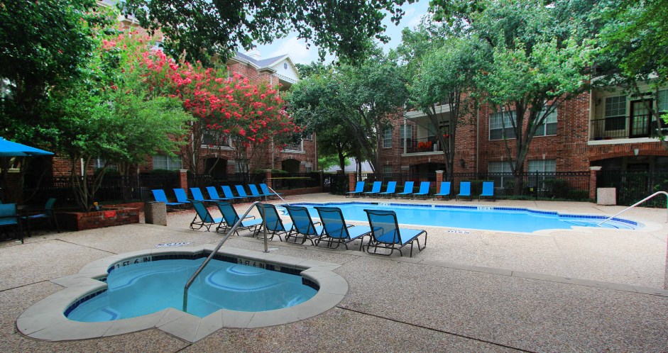 Gated community near the Galleria with brick exteriors, lush landscaping, two swimming pools with poolside lounge chairs, spa, and sauna at The Saxony Apartments