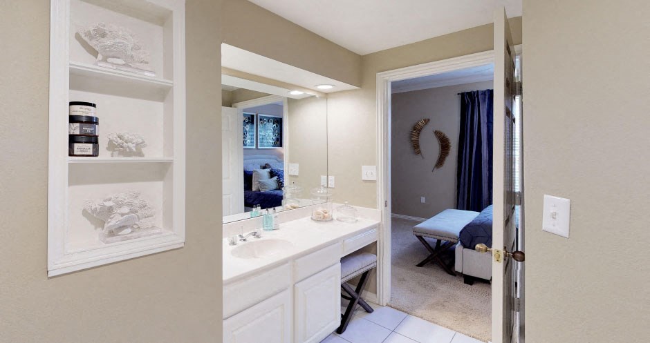 Luxury apartments with spacious bathrooms with glass showers, oval soaking tubs, built-in shelves, spacious linen closets, and cultured marble vanities at Tuscany Gate Apartments in Houston.