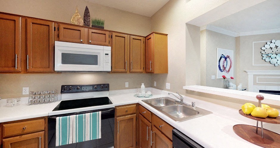 U-shaped kitchen with lots of cabinet space, lots of counter space, and porcelain tile floor bar at The Saxony Apartments in north Dallas
