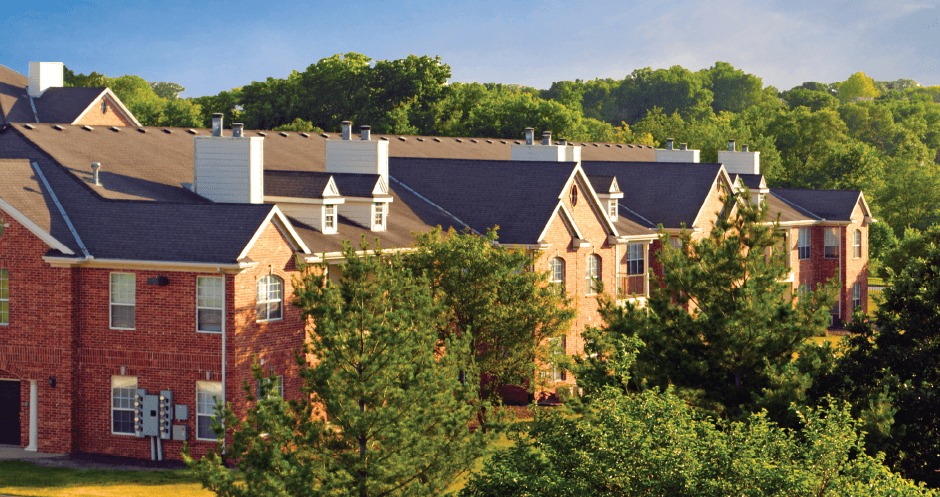 Luxury apartments with red brick exteriors, spacious balcony, and lush landscaping at TurtleCreek apartments in West Des Moines, Iowa