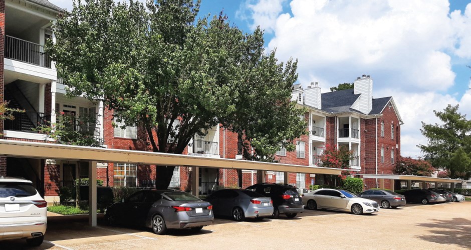 Covered car ports and red brick exteriors at Tuscany Lane Apartments in Houston.