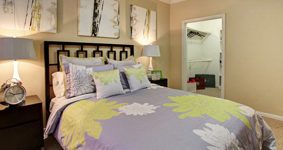 Spacious bedroom with walk-in closet and ceiling fan at Tuscany Oaks Apartments in Houston.