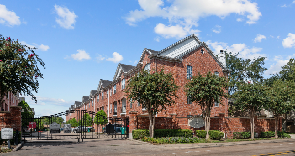 Luxury townhomes in a gated community with red brick exteriors and attached 2-car garages at Tuscany Row Townhomes in Houston.