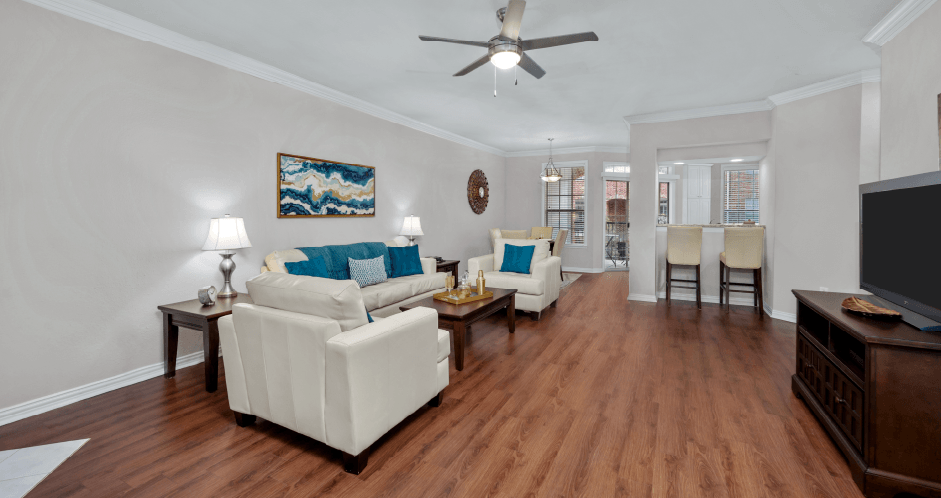 Spacious living room, huge living room with wood-burning fireplace, hardwood floors, crown molding, breakfast bar, spacious dining room, and at Tuscany Villas in Houston.