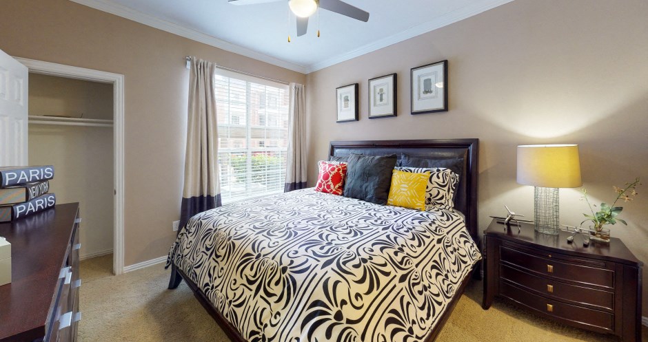 Luxury apartments with spacious bedrooms, walk-in closets, and ceiling fans at Tuscany Apartments in Houston.