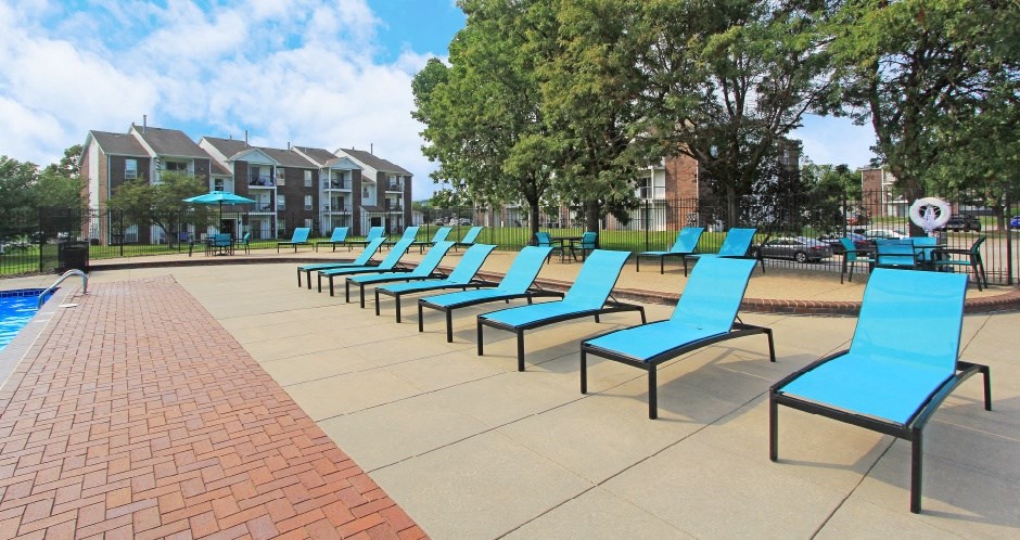 Spacious sundeck with lounge chairs, tables, and umbrellas at The Vanderbilt Apartments in Omaha Nebraska
