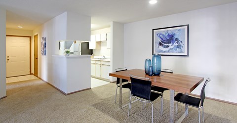 Spacious dining room area and kitchen with tiled floor, white cabinets, and lots of cabinet space at Tanglewood Apartments in Lincoln Nebraska
