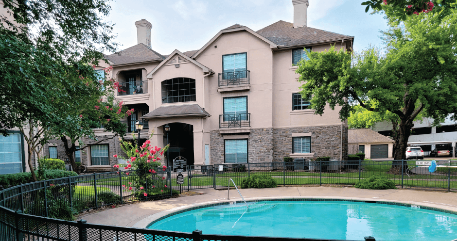 Luxury resort-style swimming pool with poolside lounges chairs, beautiful landscaping, lush landscaping and scenic views at Village on the Parkway Apartments.