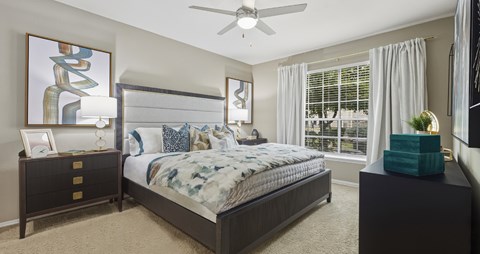 Spacious master bedroom with attached master bathroom, spacious walk-in closet and grey colored walls at Village on the Parkway Apartments in Houston, Texas
