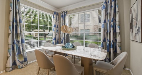 Spacious dining room with huge windows and lots of natural light at Village on the Parkway Apartments in Houston Texas