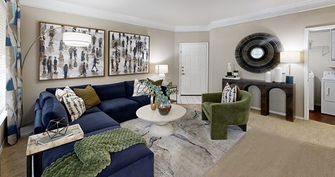 A living room with a blue couch and a green armchair.