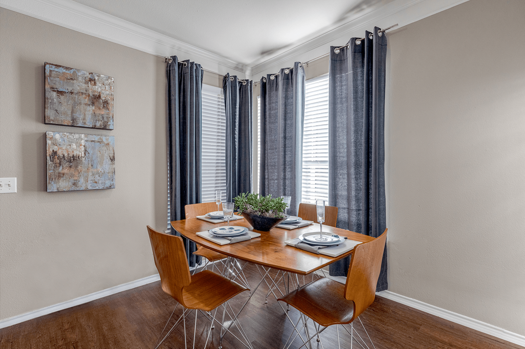 a dining room with a table and chairs and a window