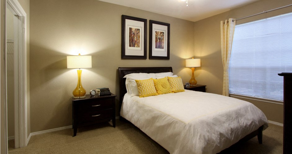 Spacious master bedroom with attached master bathroom and spacious walk-in closet with 9-foot ceilings at Village on the Parkway Apartments.