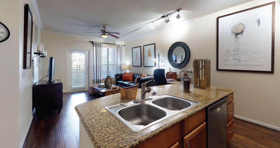 Luxury apartments in Houston with spacious open floor plan with granite countertops, kitchen island, stainless steel appliances, oversized windows, and hardwood floors.