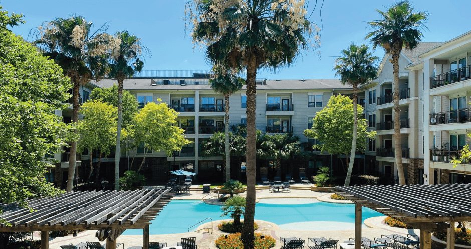 Luxury swimming pool with cabanas, poolside lounges, grilling stations, palm trees and beautiful landscaping at The Voss Apartments in Houston.