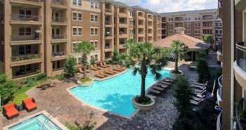 Luxury apartments with palm trees, spa, hot tub, spacious sundeck with poolside lounge chairs, beautiful landscaping, and fountains at Villa Piana Apartments in Dallas - Photo Gallery 33