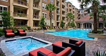 Luxury apartments with resort-style pool, spa, palm trees, spacious sundeck with poolside lounge chairs, grilling station, and fountains at Villa Piana Apartments in Dallas - Photo Gallery 13