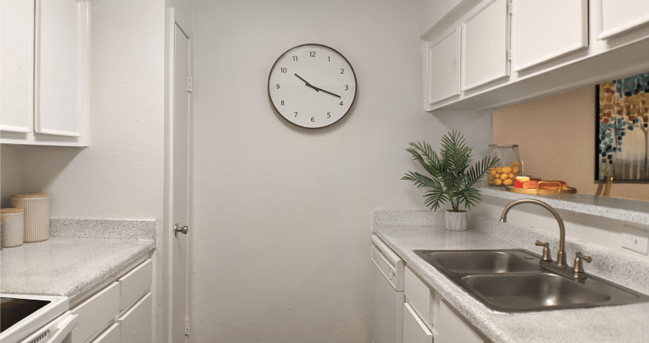 Bright white kitchens with wood plank floors at Waters of Winrock Apartments in Houston
