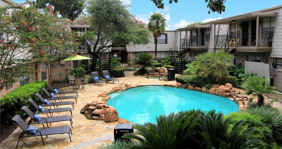 Gated apartment community with pool, spa, poolside lounge chairs, lush landscaping, beautiful landscaping, and neighborhood setting in Houston, Texas