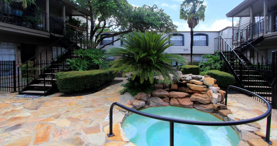 Gated apartment community close to the Galleria with pool, spa, poolside lounge chairs, lush landscaping, beautiful landscaping, and neighborhood setting.