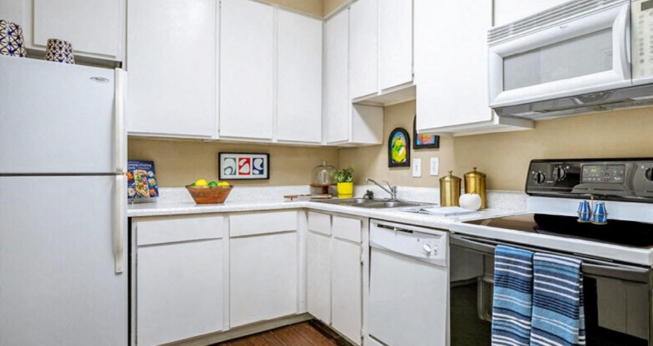 Bright kitchen with white cabinets and breakfast bar at Woodlake Oaks Apartments in Houston bar at Woodlake Oaks Apartments in Houston