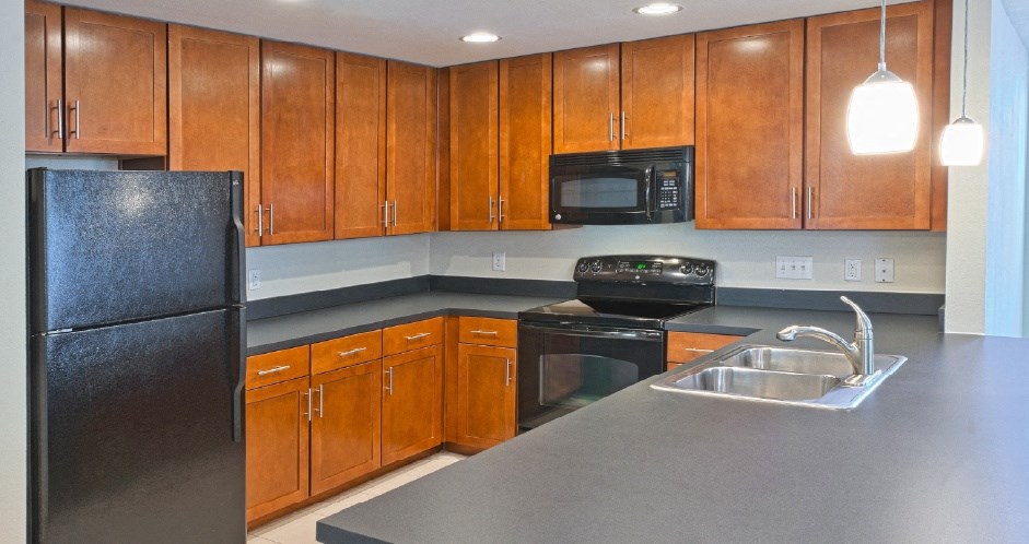 a kitchen with black appliances and wooden cabinets