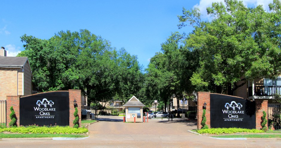 Gated apartments with 2 swimming pools, convenient bayou location, lush landscaping, and scenic views at Woodlake Oaks Apartments in Houston.