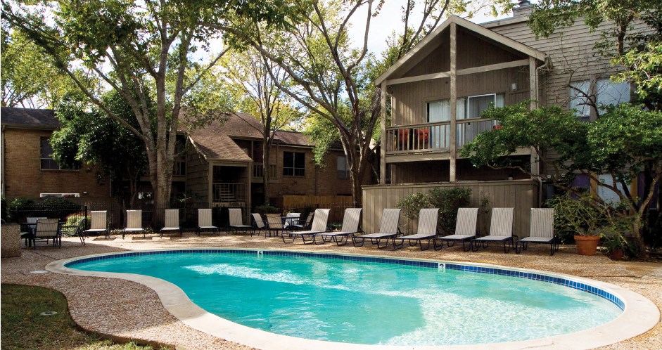 Gated apartments with 2 swimming pools, convenient bayou location, lush landscaping and scenic views at Woodlake Oaks Apartments in Houston.