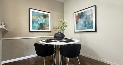 A dining room with a white table and chairs.