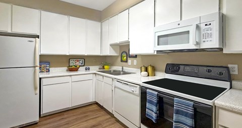 A kitchen with white cabinets and appliances.