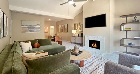 A living room with a green couch and a fireplace.