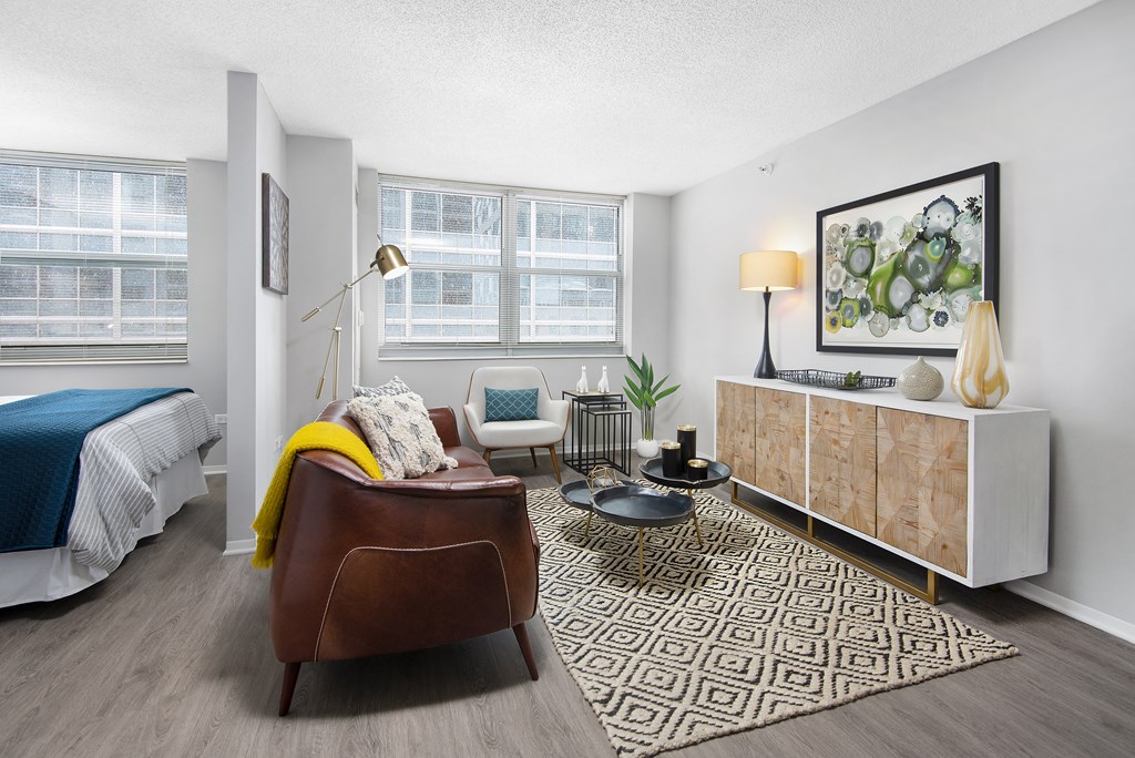 a living room with a couch and a chair and a bed