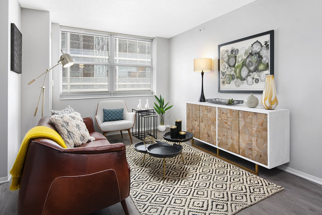 a living room with a couch and a dresser and two windows