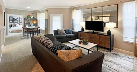 A living room with a brown couch and a wooden cabinet.