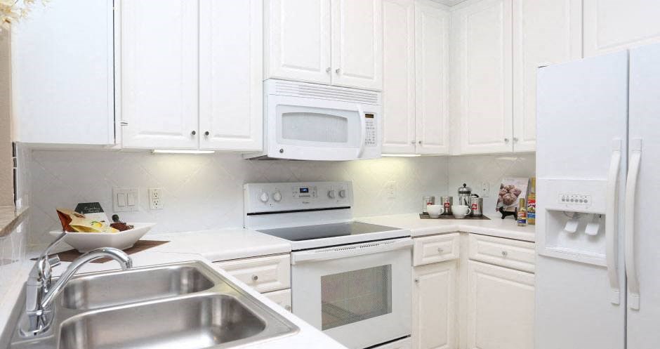 a white kitchen with white appliances and white cabinets