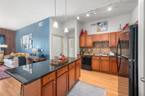a kitchen with wooden cabinets and a black counter top