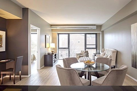 A dining room with a glass table surrounded by chairs.
