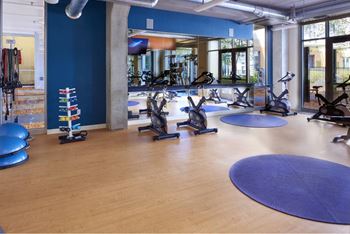 A gym with exercise equipment and a blue wall.